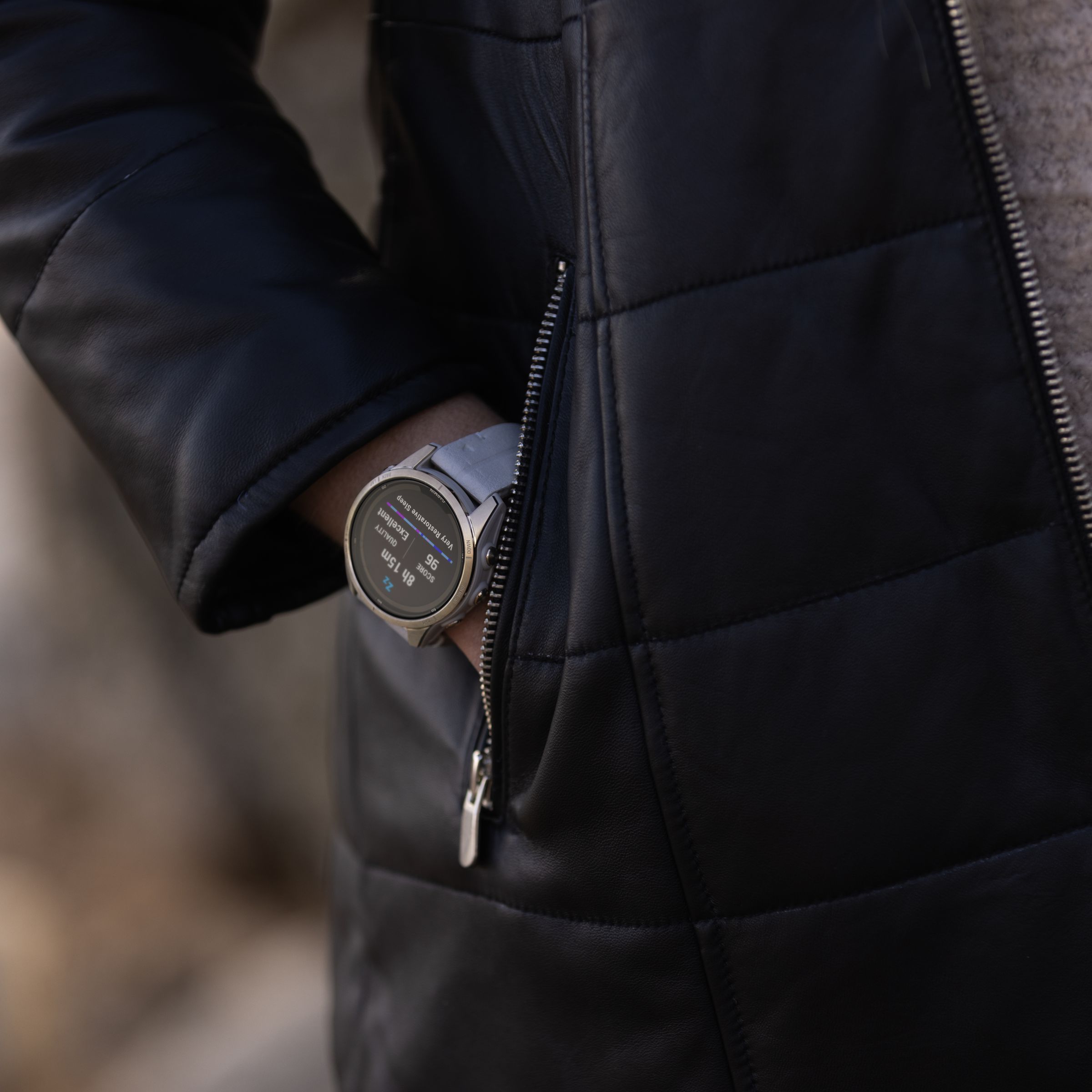 Close up of the Fenix 7 Pro worn on a wrist as someone puts their hand in a jacket pocket