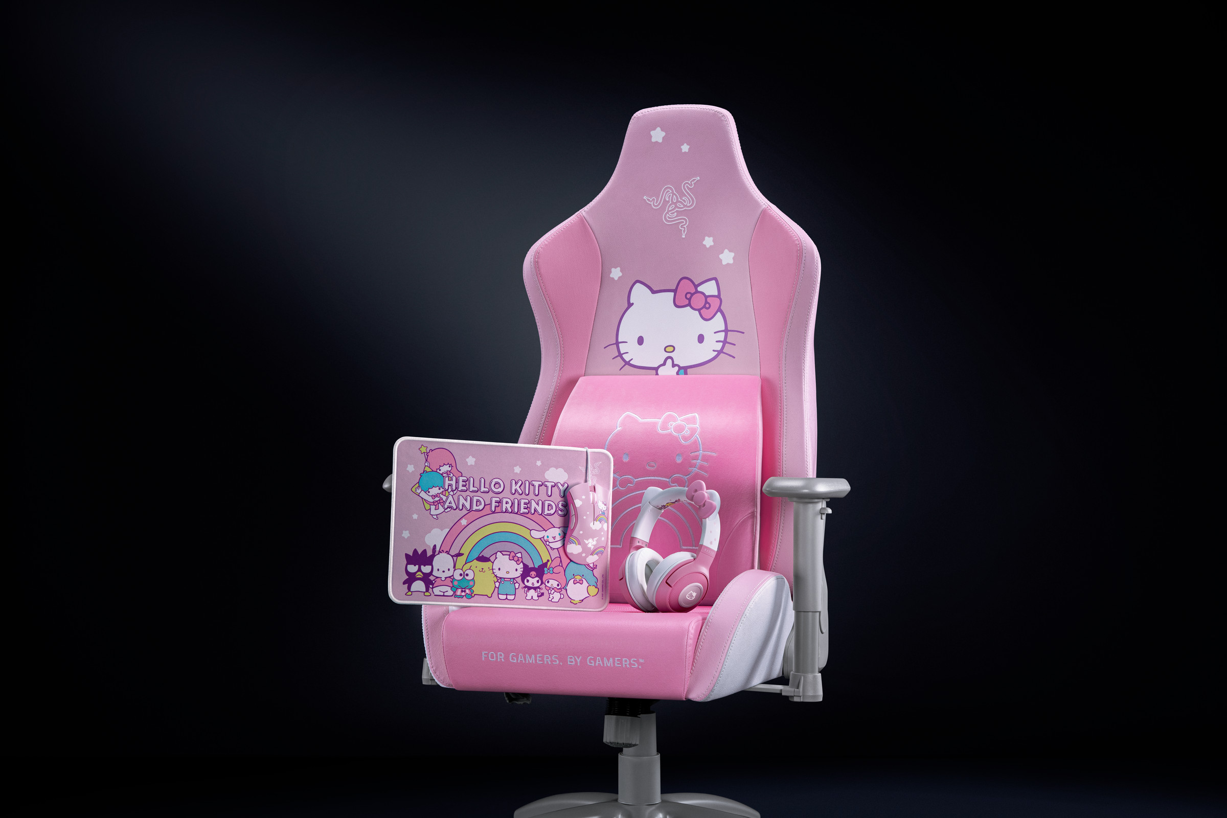 Razer’s Hello Kitty chair in front of a black background. On the chair are the Hello Kitty lumbar cushion, headset, mousepad and mouse.