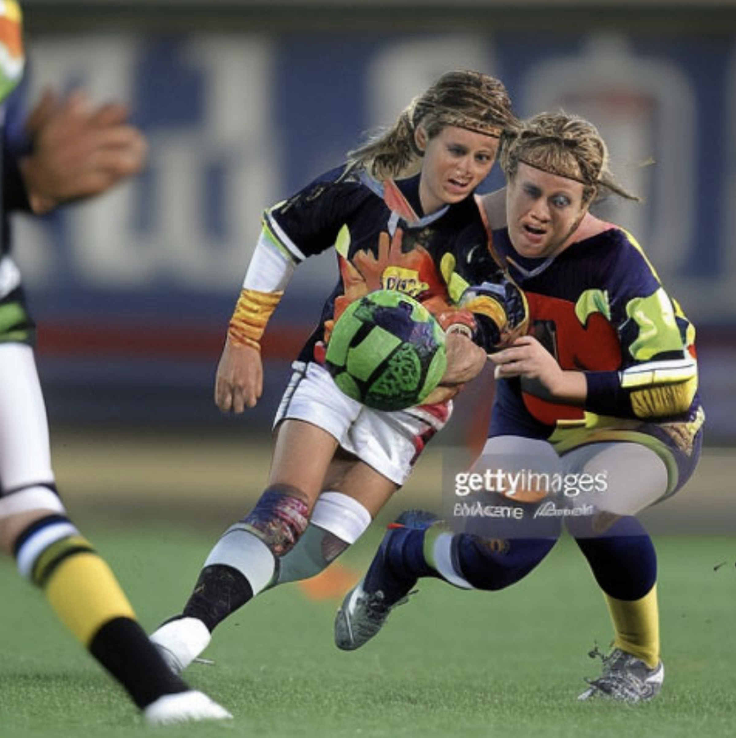An AI generated image that appears to show two female soccer players. Their limbs and faces are bizarrely distorted though, with extra fingers and indistinct facial features. 