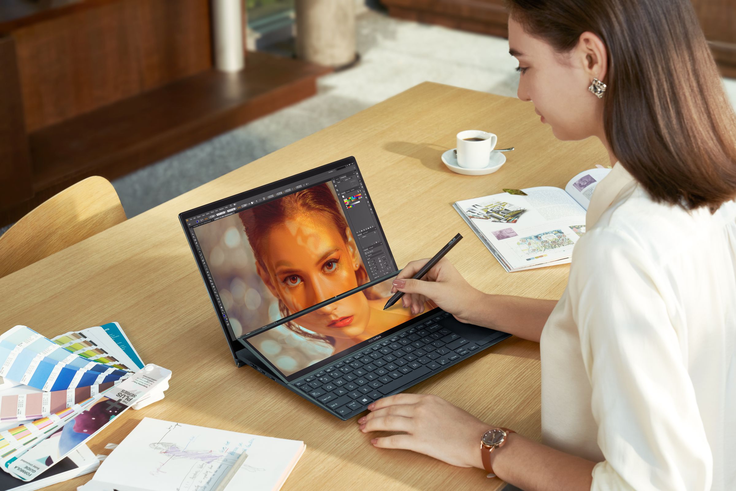 A user edits a photo using a stylus on the Asus Zenbook Duo 14.