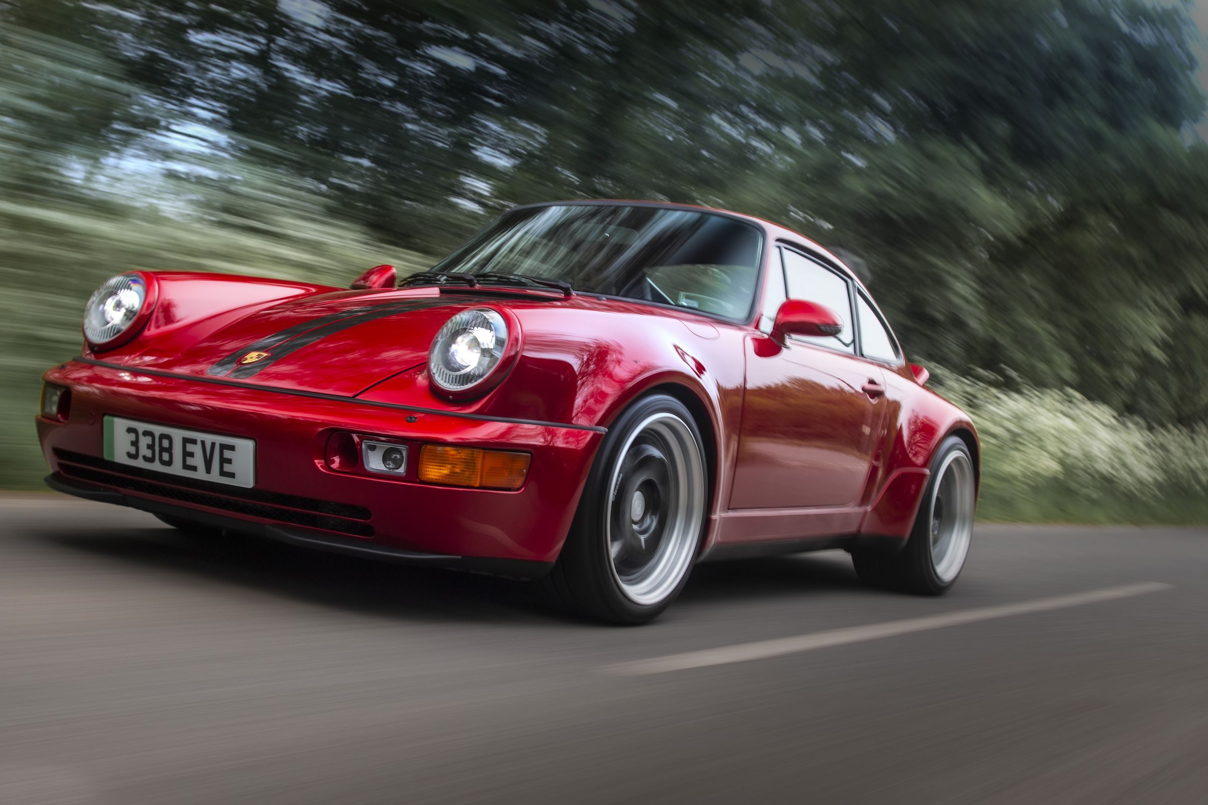 Red classic Porsche 911 964 driving on street