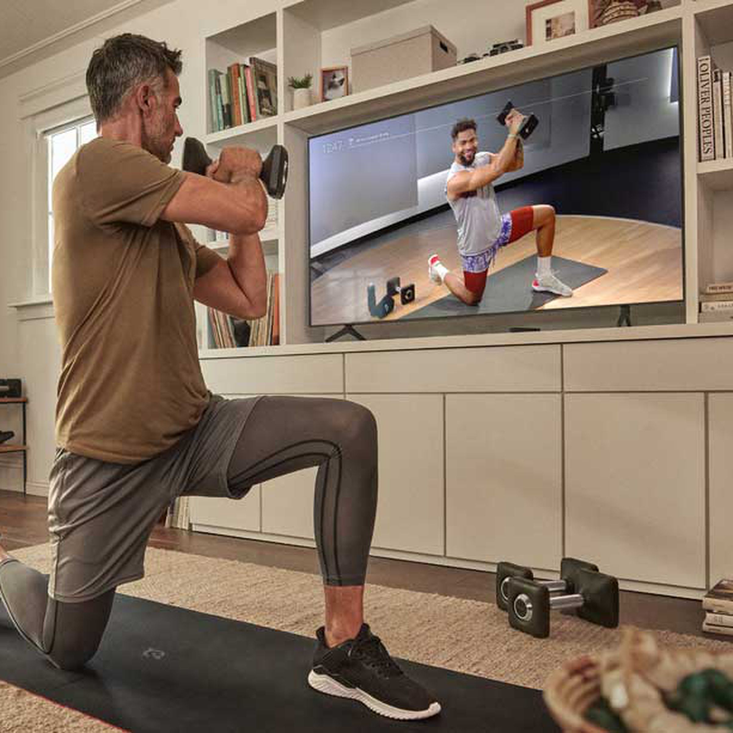 A man lifting weights during a virtual strength training class.