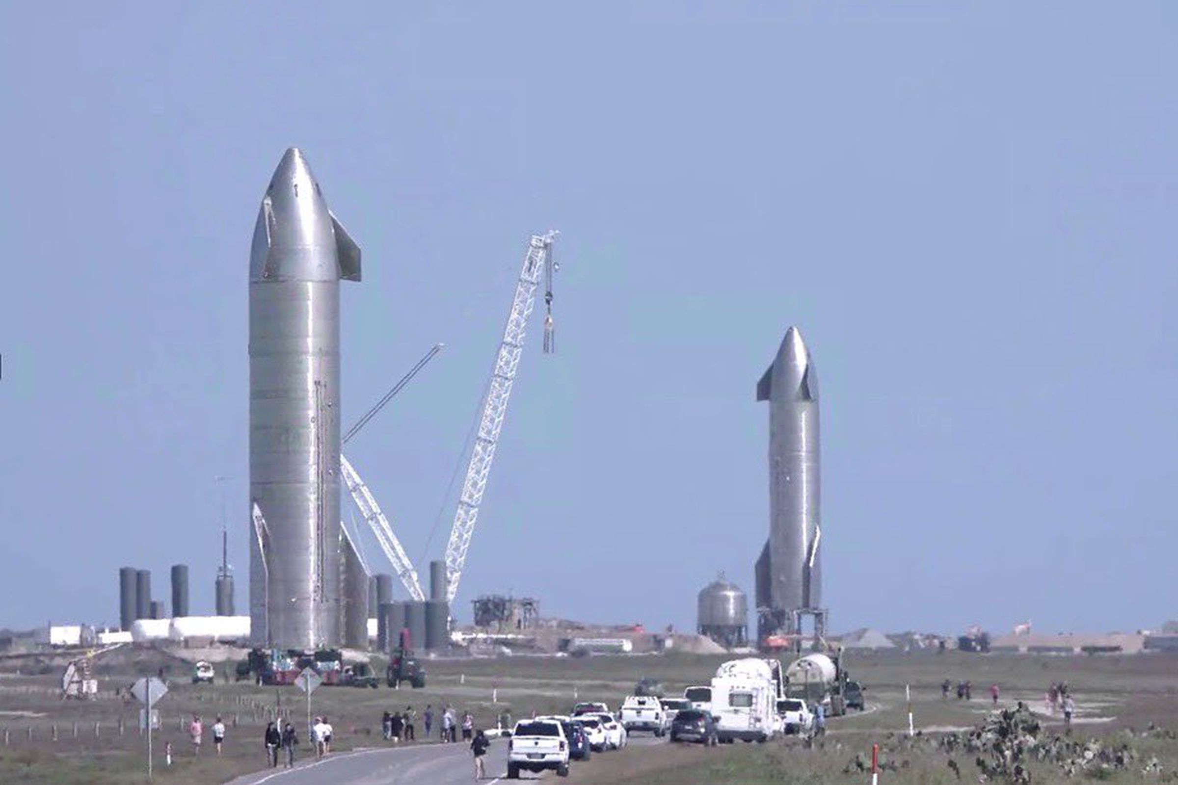 Two since-destroyed Starship prototypes stand erect at SpaceX’s Boca Chica, Texas Starship facilities.