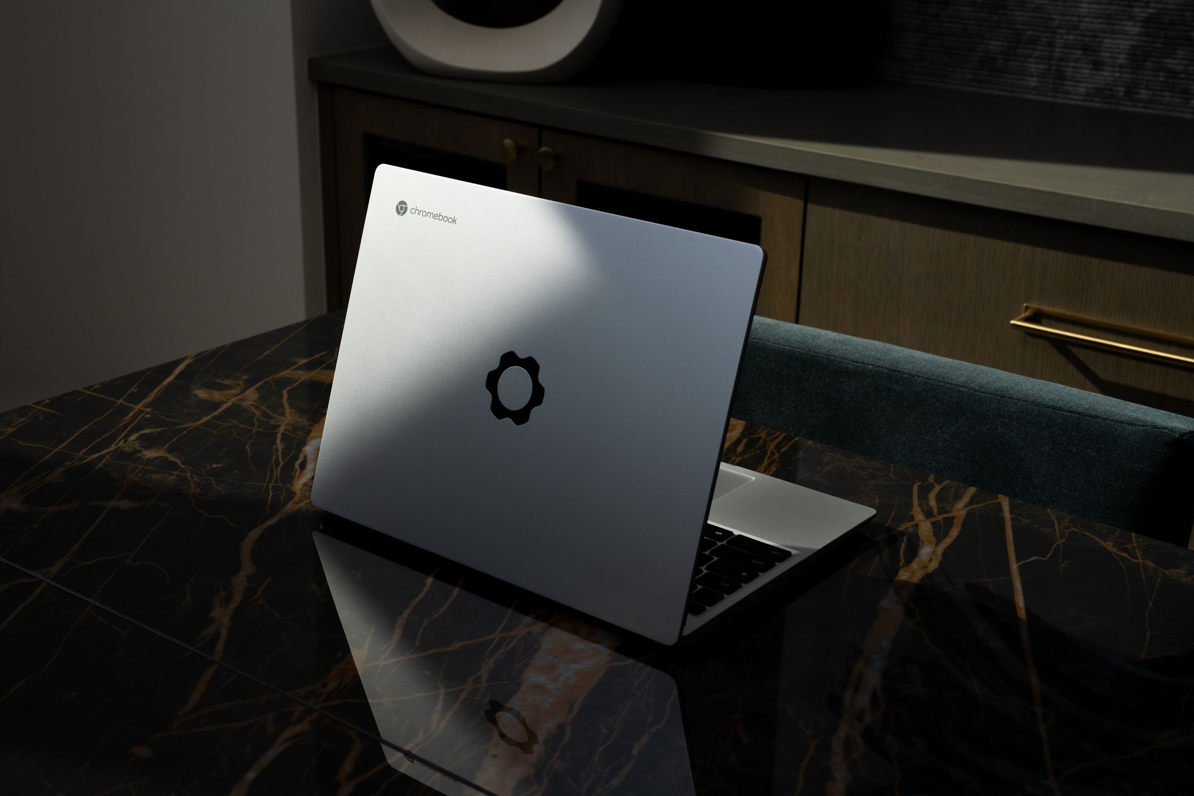 The Framework Laptop half open on a marble counter seen from the back.