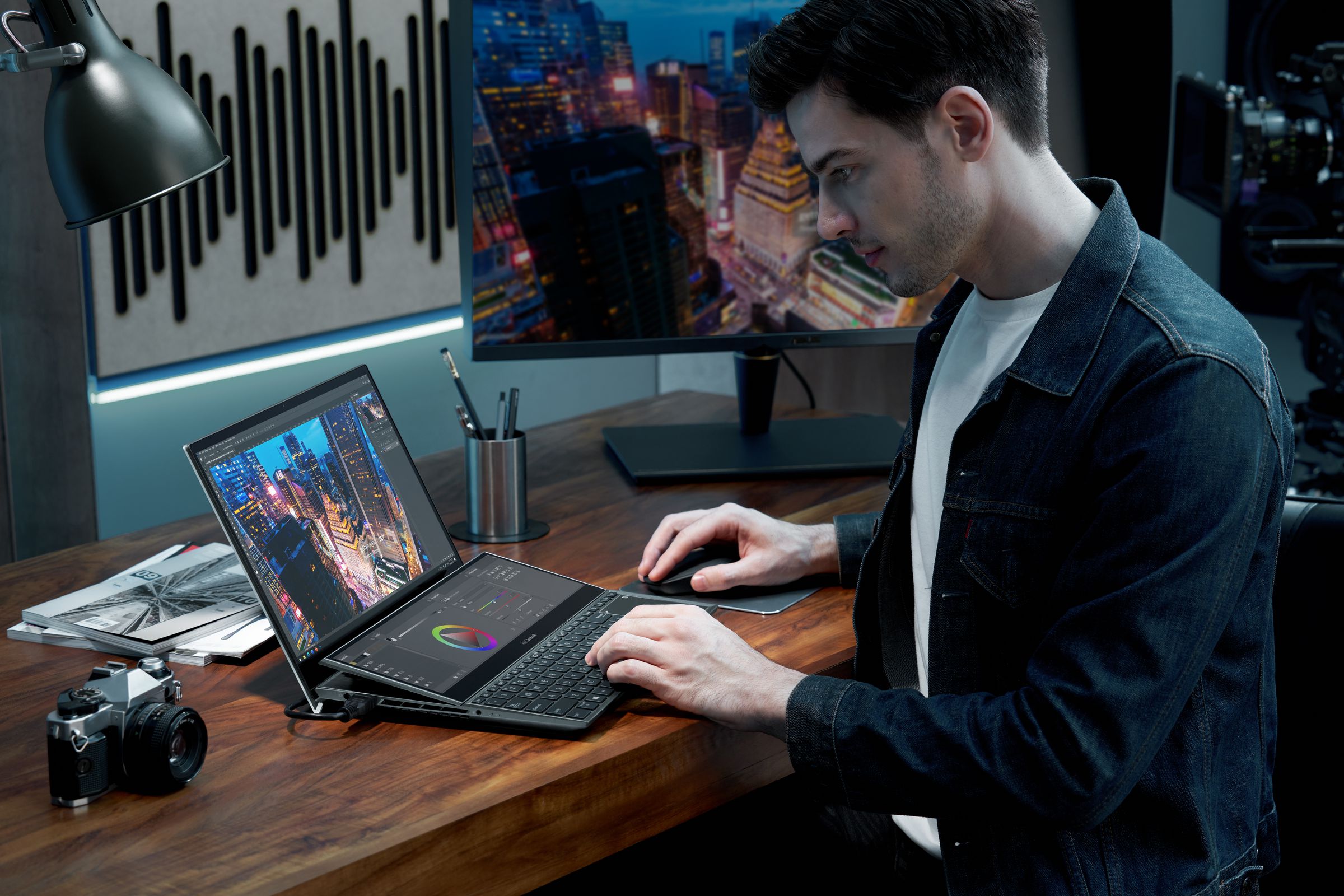 A user types on the Zenbook Pro Duo 15 OLED in a low-lit office space. 
