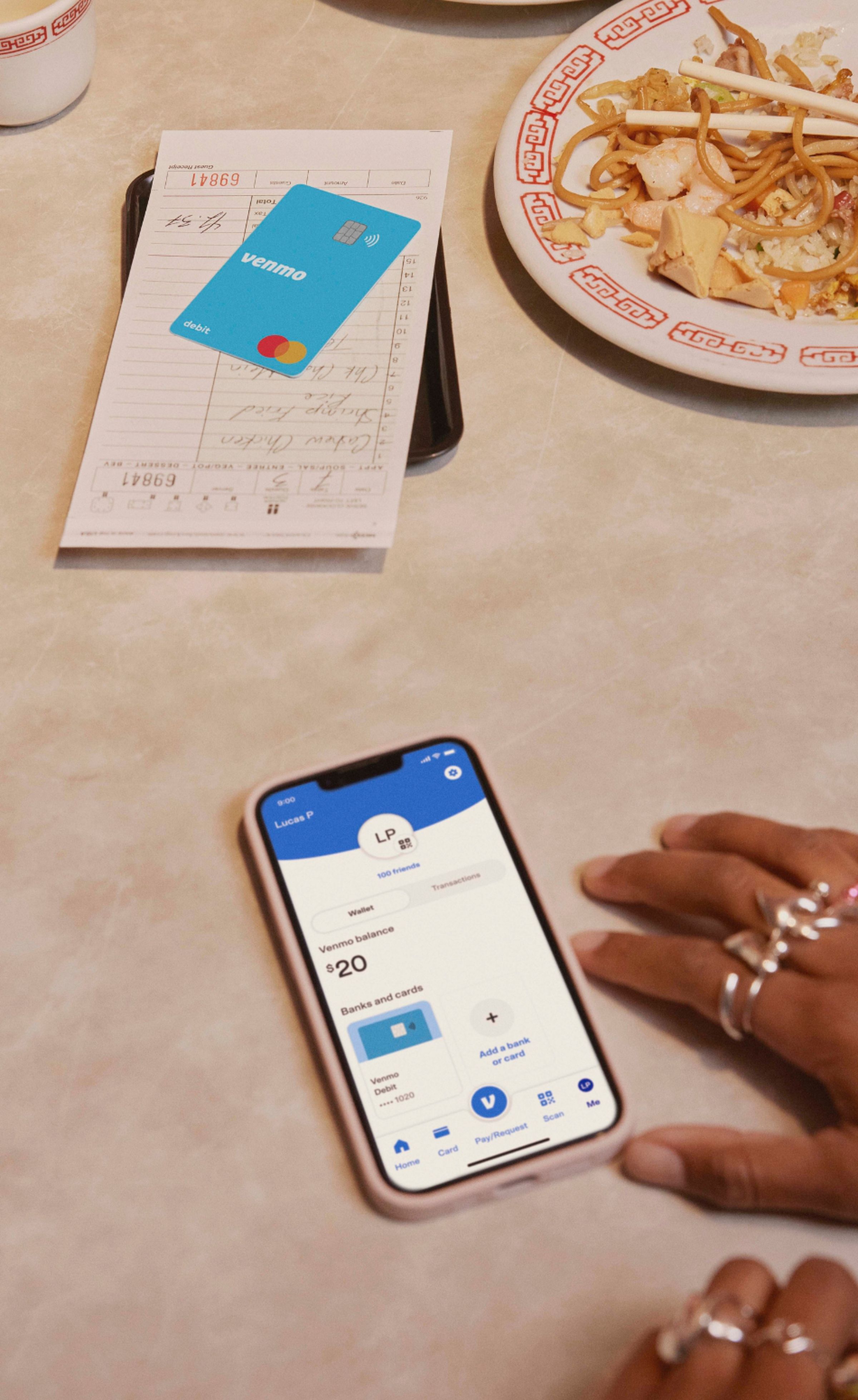 Someone using the Venmo app while ordering food. A Venmo card can be seen on the table.