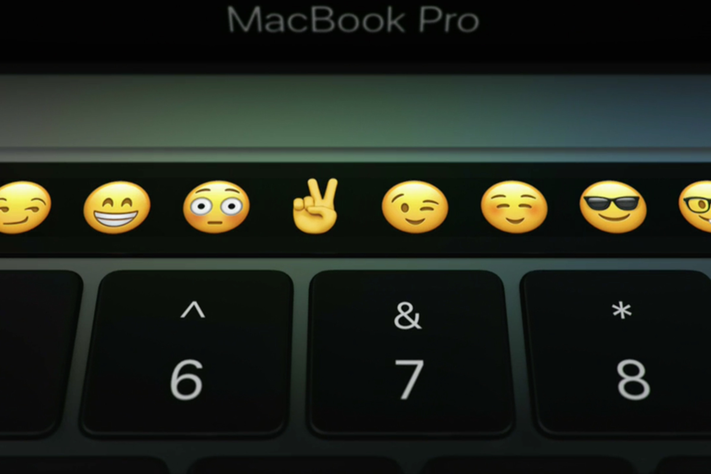 An image of the Apple Touch Bar. There is a row of emoji including the peace sign and a flushing face.