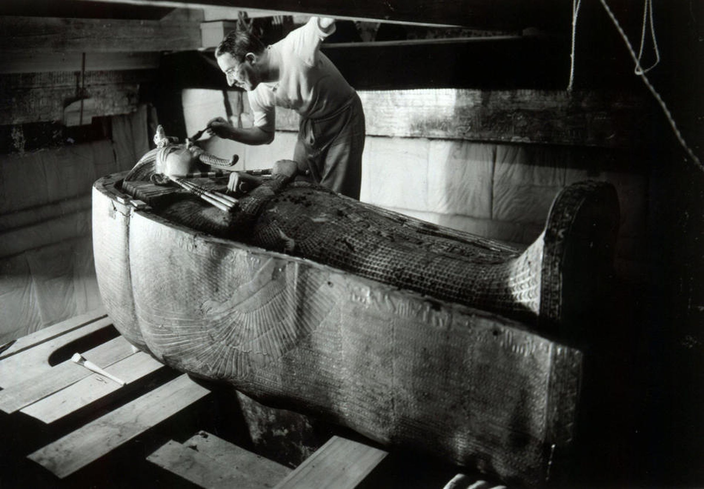 Howard Carter, the man who discovered Tutankhamen, examines his sarcophagus. 