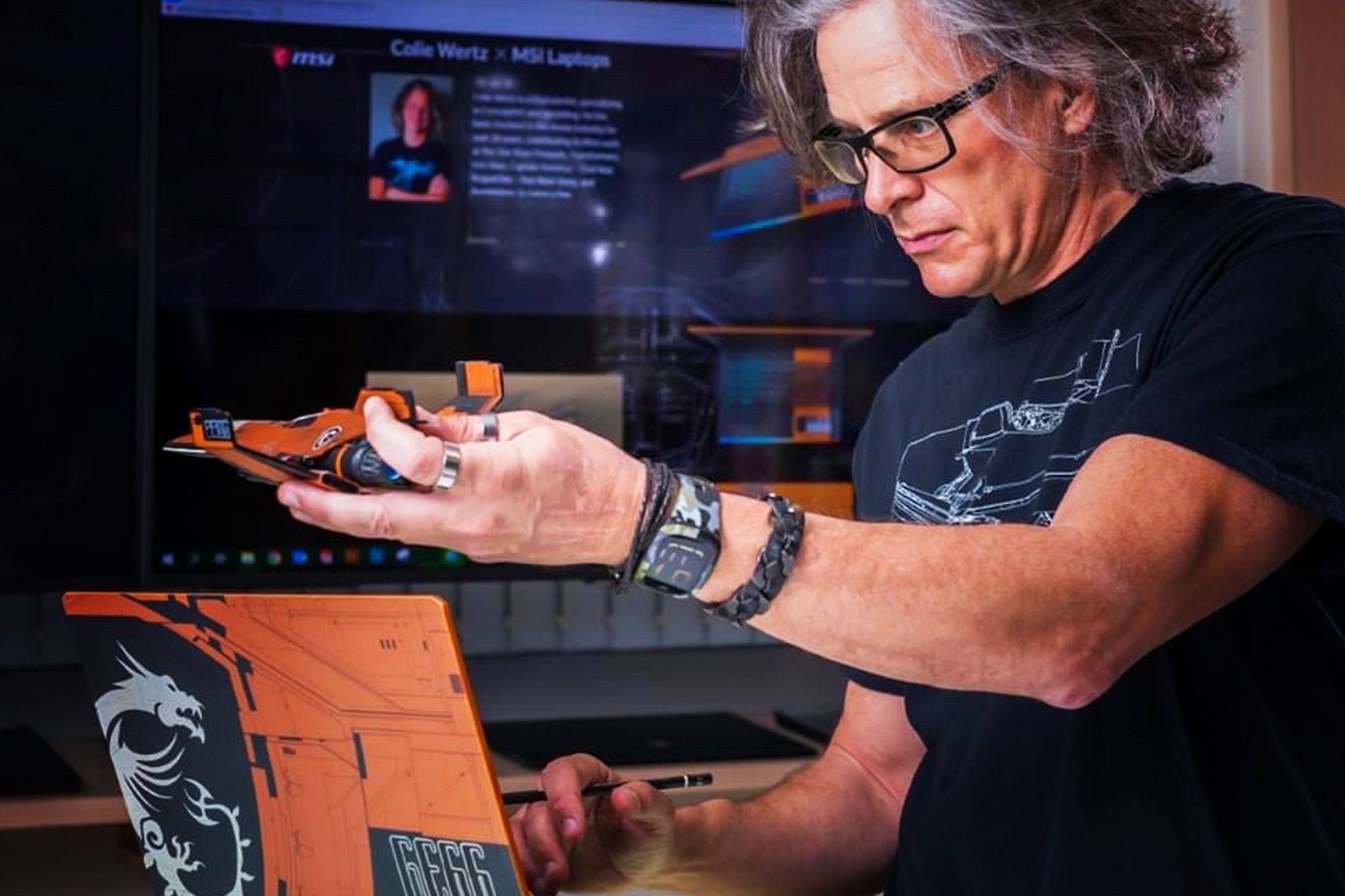 Colie Wertz uses the MSI GE66 Raider Dragonshield Edition while holding a model spaceship.