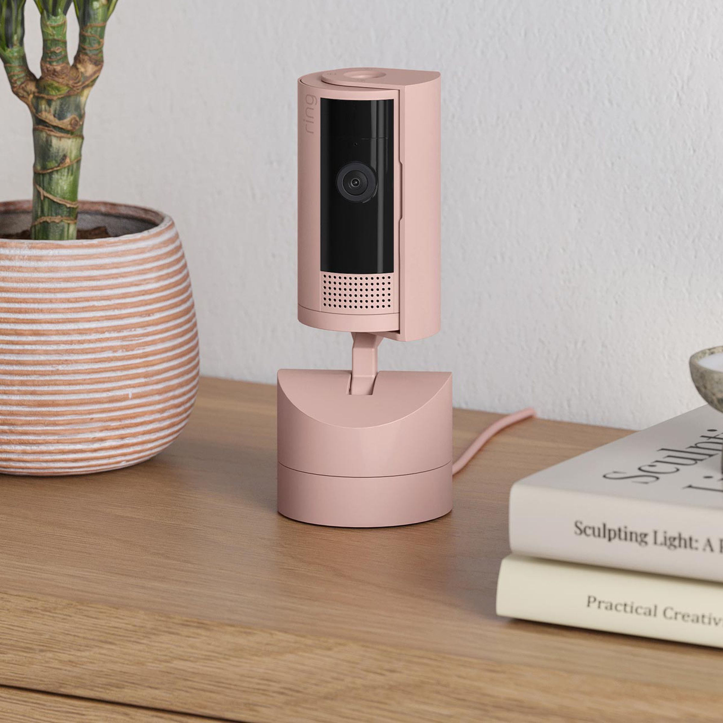 A pink security camera on a table.