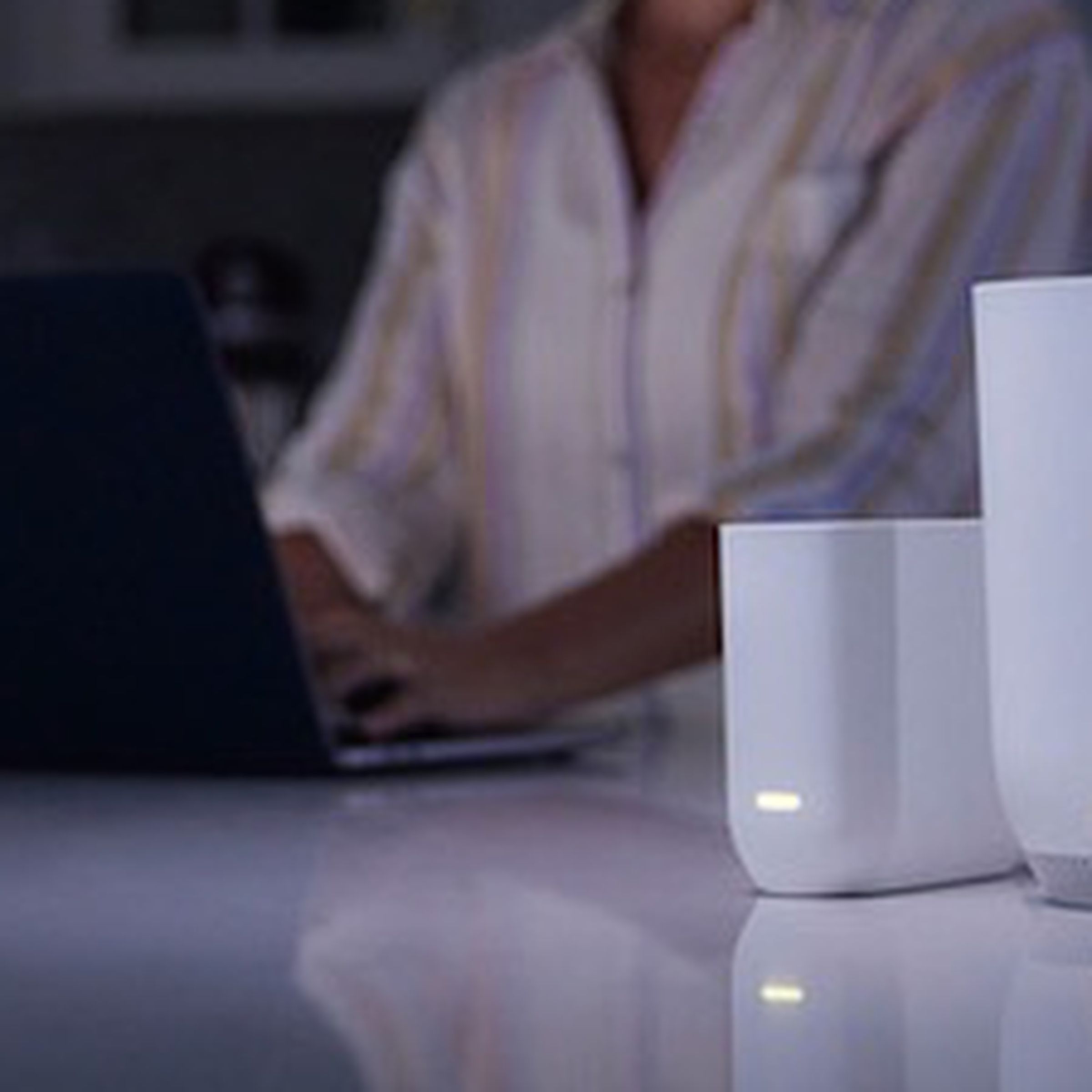 The Xfinity Storm-Ready WiFi on a table in a dark kitchen.