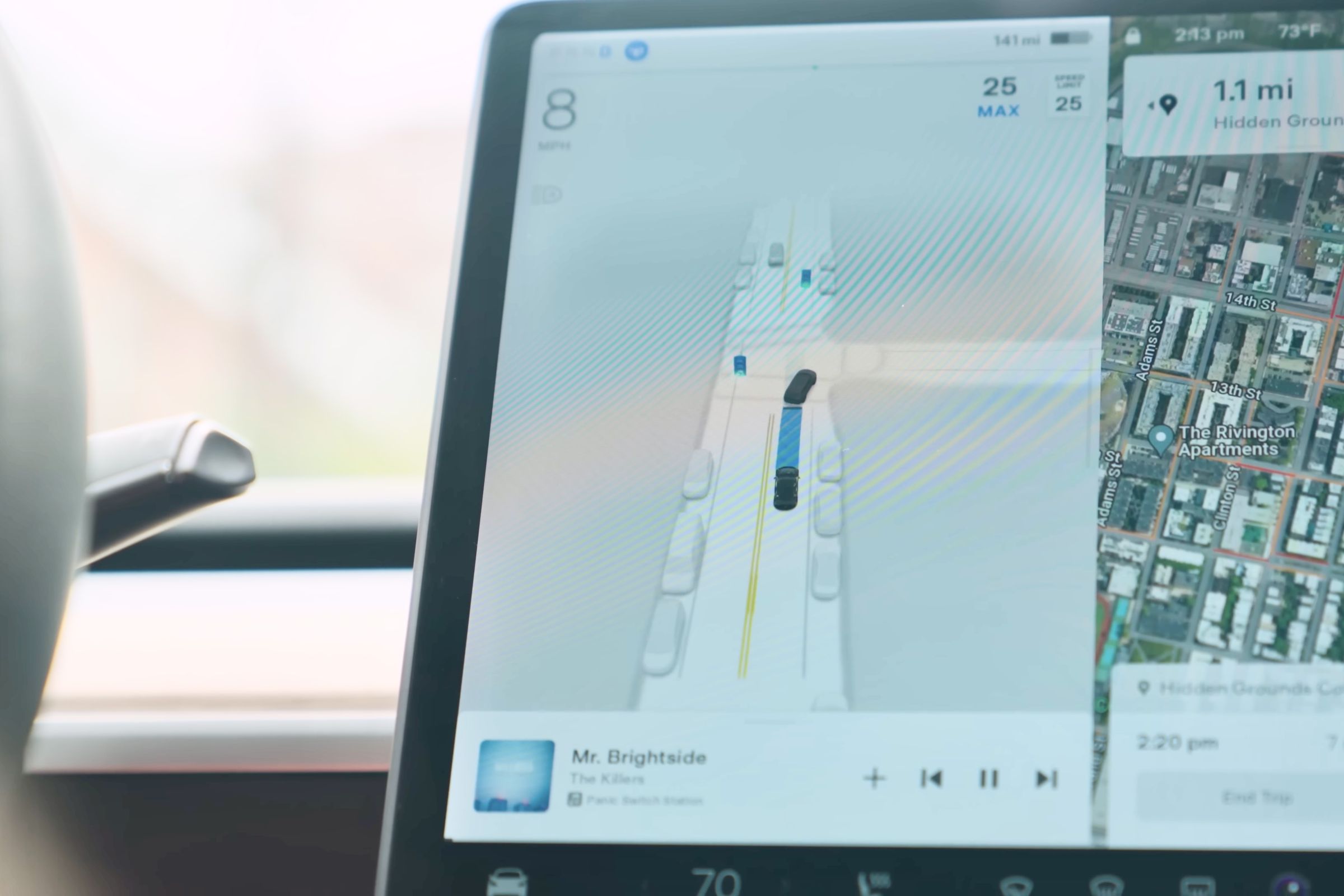 left side of Tesla model 3 main screen showing a computer generated image of an intersection with cars parked on the sides and the model 3 following another car