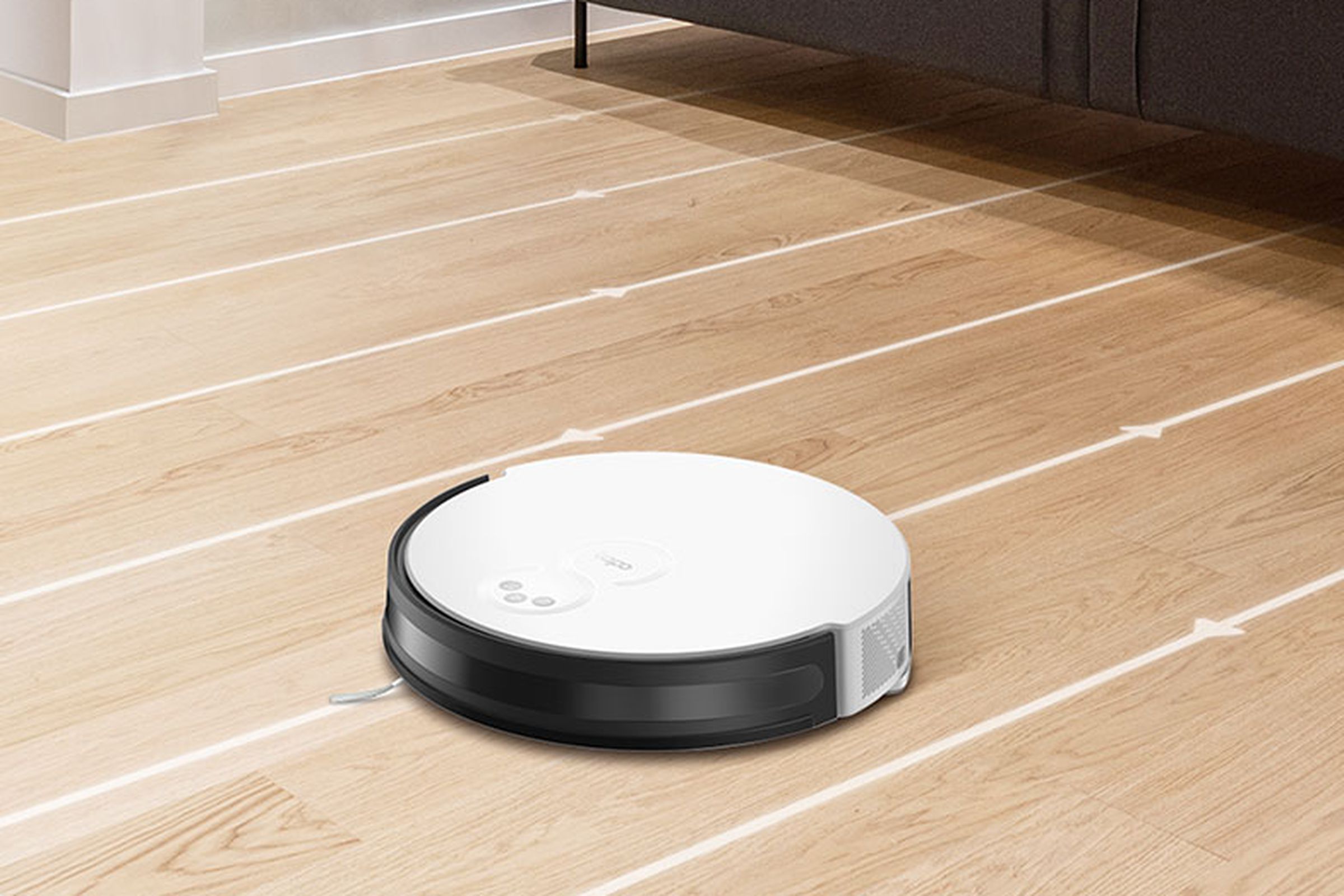 A white robot vacuum on a hardwood floor